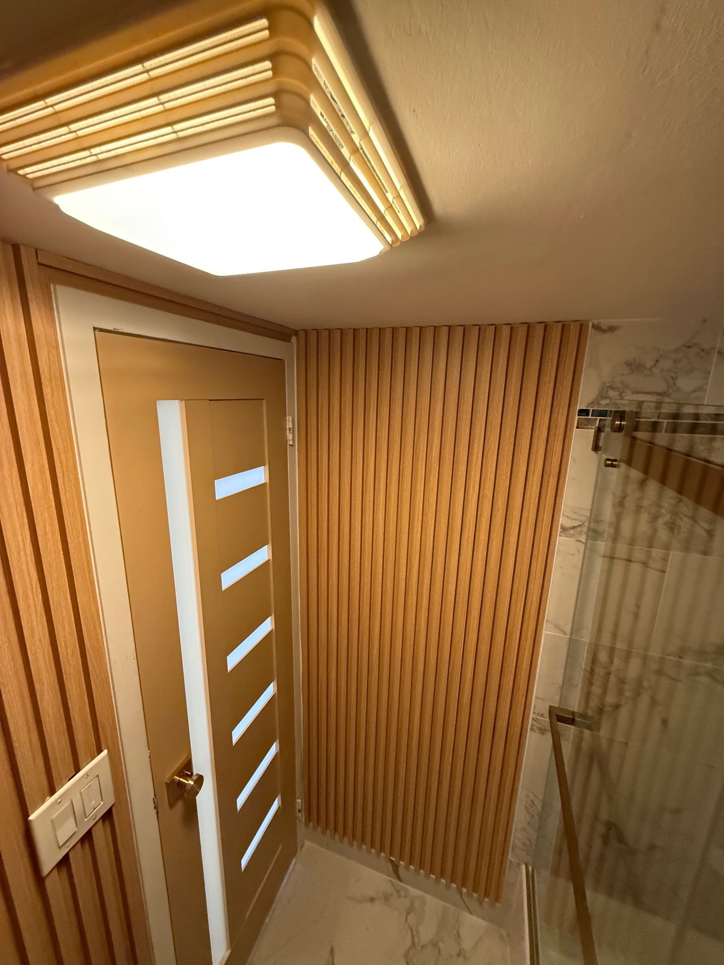 Interior door and slatted wood wall in a finished space